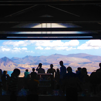 Grupo de pessoas apreciando a vista de montanhas e uma praia