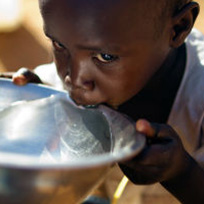 Criança negra bebendo água em uma tigela prata / Foto: United Nations Photo