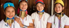 Quatro mulheres da tribo Padaung, da Tailândia usando anéis de cobre no pescoço em sinal de beleza.